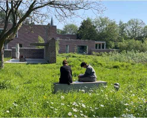 2 counselling studenten oefen samen in de tuin van het opleidingsinstituut